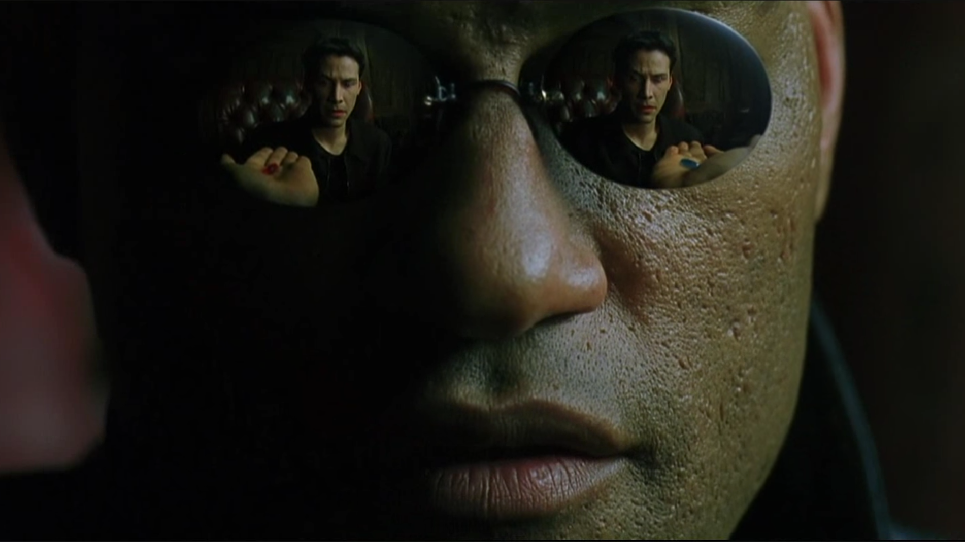 A man wearing glasses, with a red pill in one lens, and a blue pill in the other lens